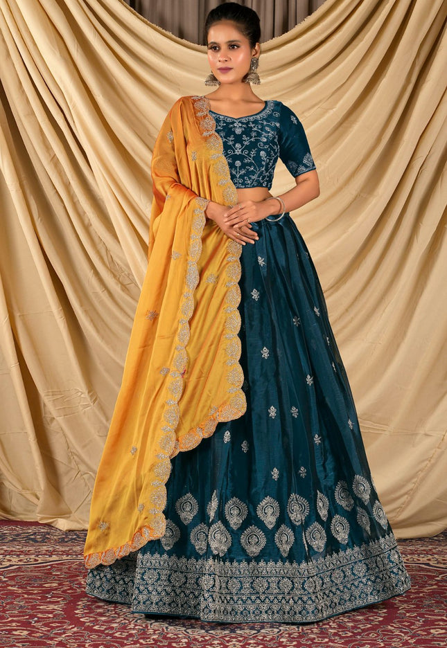 Woman wearing a traditional blue and yellow lehenga choli with dupatta