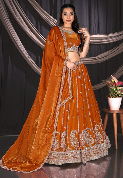 Woman in an orange embroidered traditional lehenga choli
