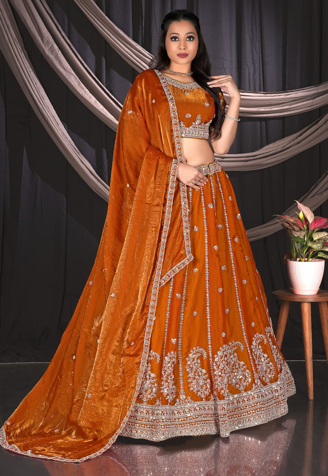 Woman in an orange embroidered traditional lehenga choli