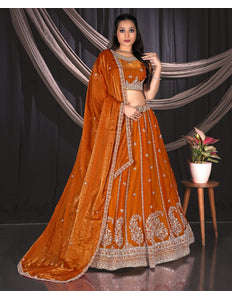 Woman in an orange embroidered traditional lehenga choli