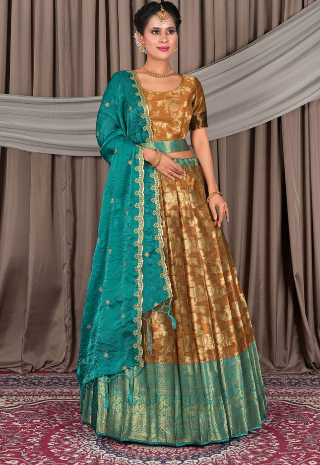 Woman wearing a traditional gold and teal outfit with a matching dupatta