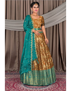 Woman wearing a traditional gold and teal outfit with a matching dupatta