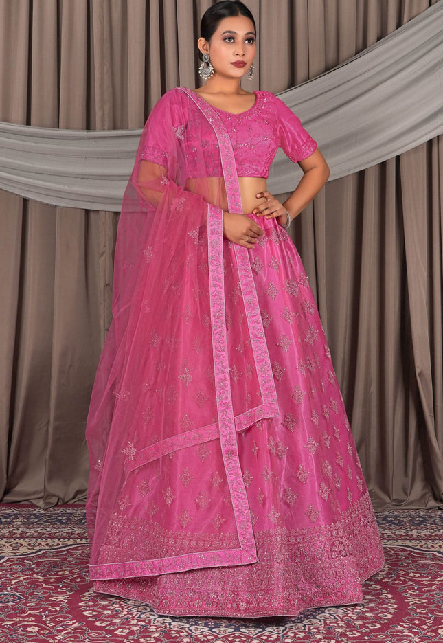 Woman wearing a pink traditional outfit with a matching dupatta