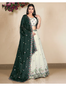Woman wearing a dark green and white embroidered lehenga choli