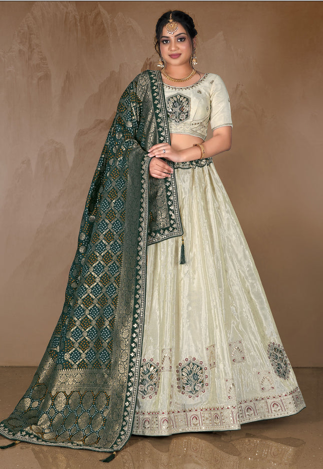 Woman wearing a traditional embroidered outfit with a green dupatta