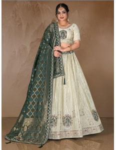 Woman wearing a traditional embroidered outfit with a green dupatta