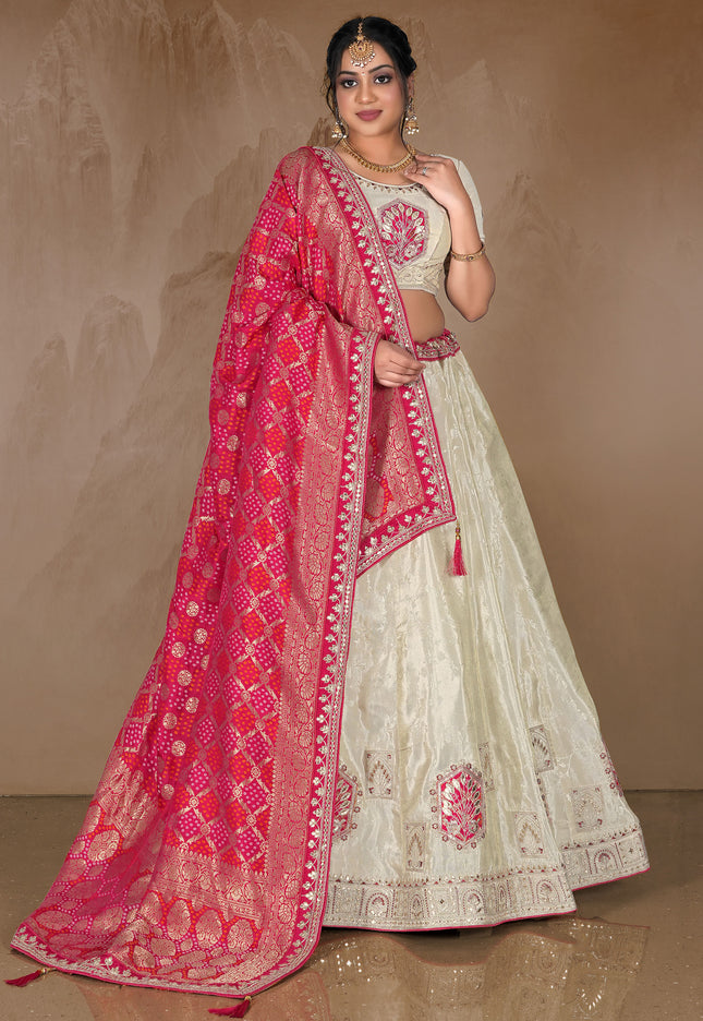 Woman wearing a traditional White lehenga with a pink dupatta