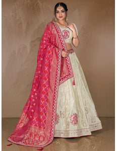 Woman wearing a traditional White lehenga with a pink dupatta