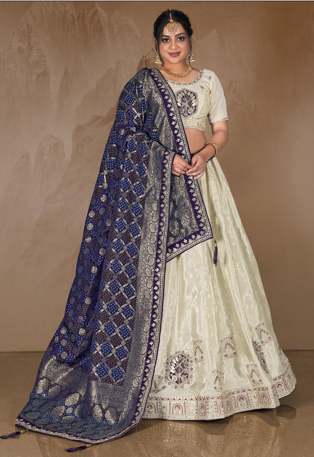 Woman wearing a traditional white and blue embroidered lehenga choli