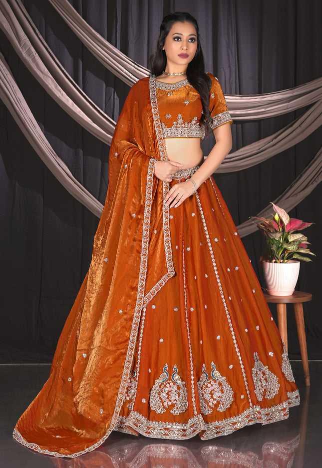 Woman in an orange embroidered traditional lehenga choli with matching dupatta