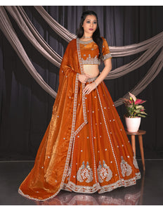 Woman in an orange embroidered traditional lehenga choli with matching dupatta