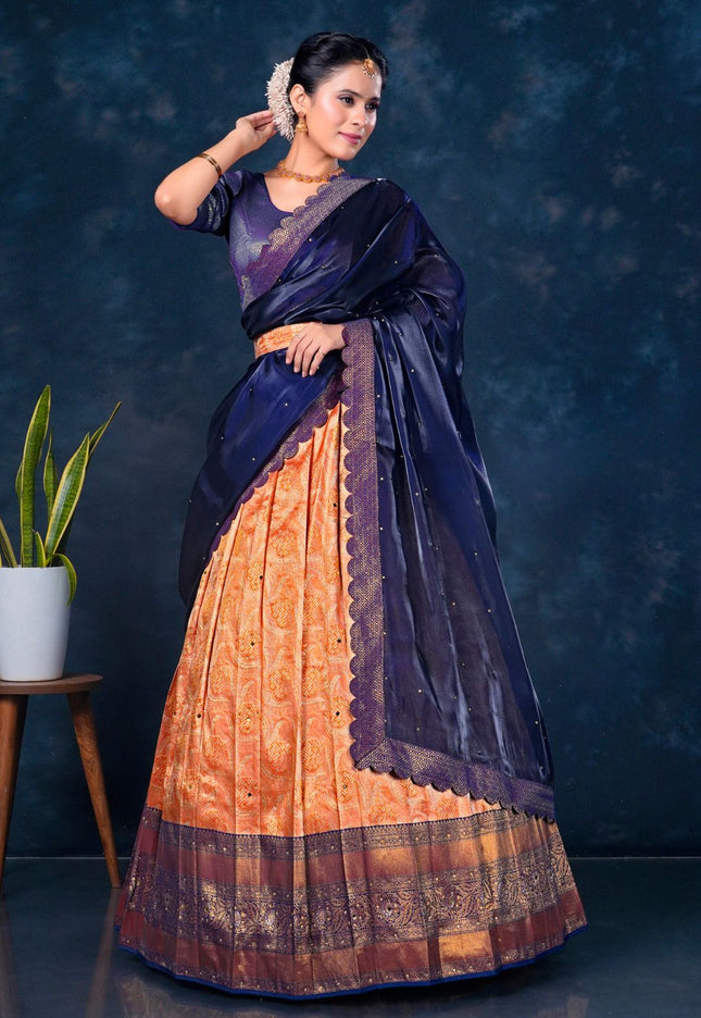 Woman wearing a traditional lehenga with a dark blue and orange pattern