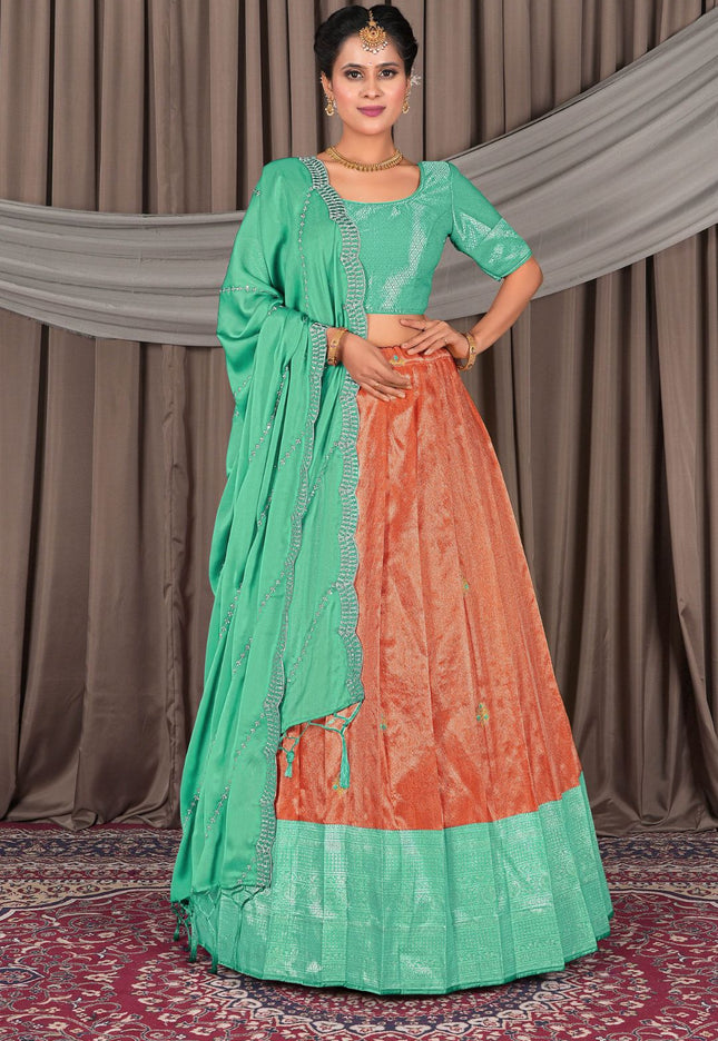 Woman wearing a traditional green and orange lehenga choli
