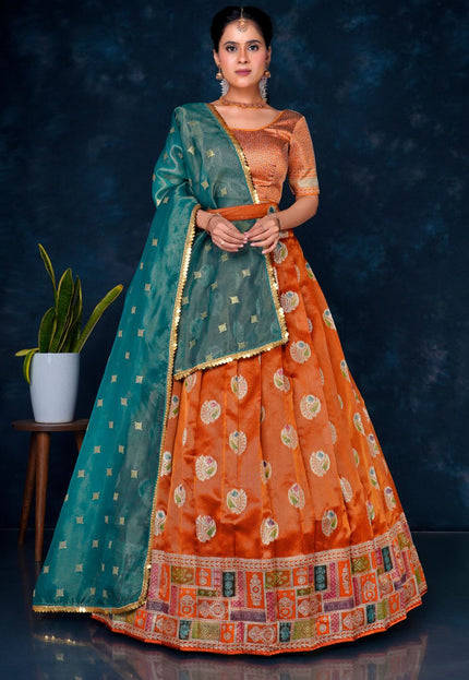 Woman wearing an orange and green traditional half saree