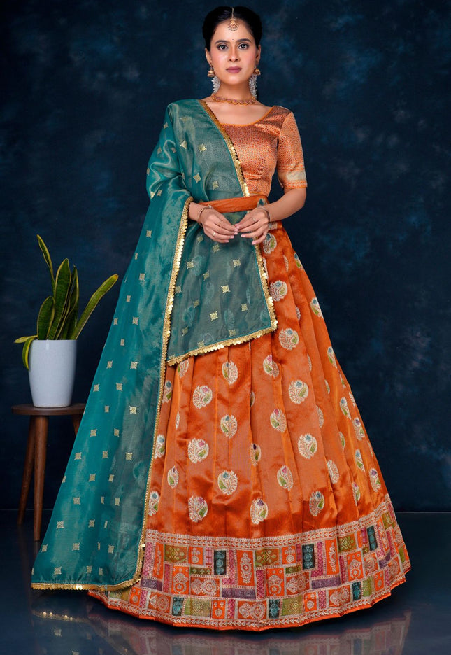 Woman wearing an orange and green traditional half saree