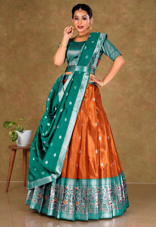 Woman wearing a traditional outfit with a green and orange lehenga choli