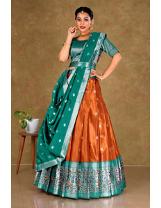 Woman wearing a traditional outfit with a green and orange lehenga choli