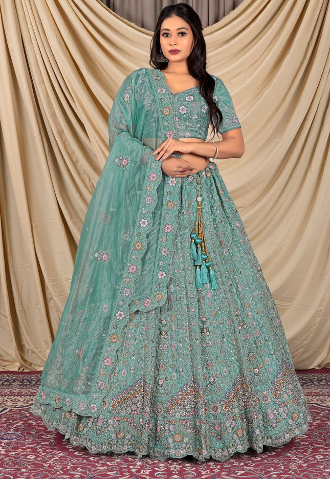 Woman wearing a teal traditional outfit with a matching dupatta