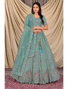 Woman wearing a teal traditional outfit with a matching dupatta