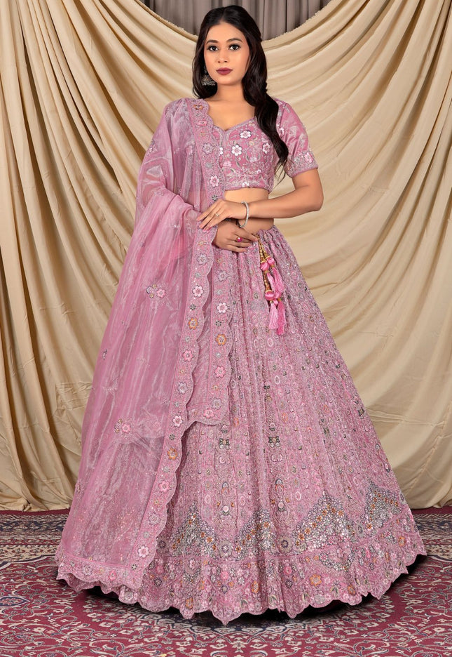 Woman wearing a pink embroidered lehenga with a matching dupatta