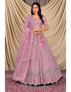 Woman wearing a pink embroidered lehenga with a matching dupatta
