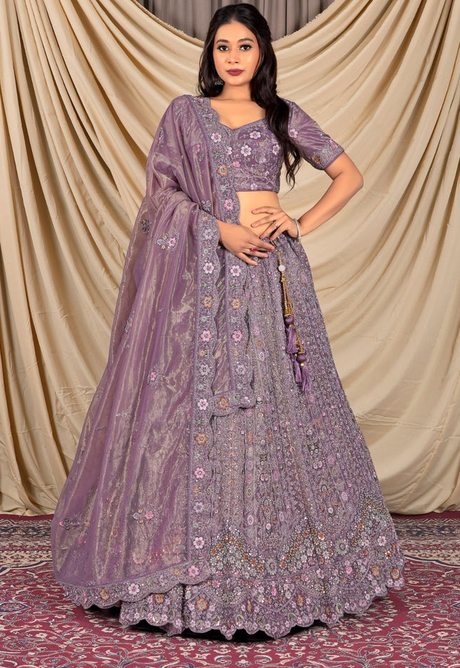 Woman wearing a purple embroidered traditional lehenga choli with dupatta