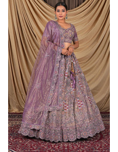 Woman wearing a traditional purple embroidered lehenga choli