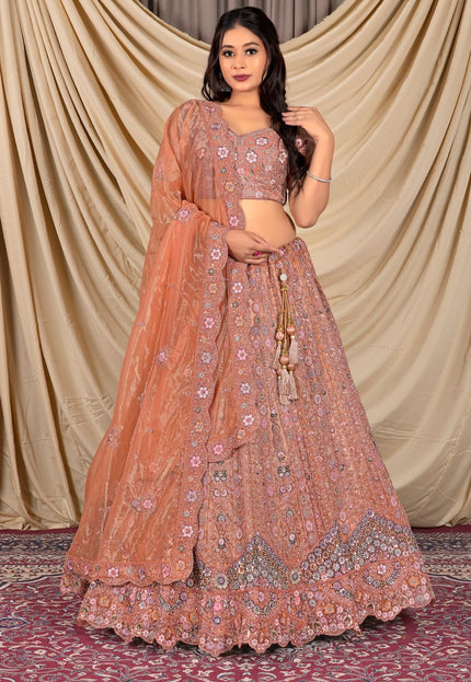Woman wearing a traditional peach lehenga with floral patterns