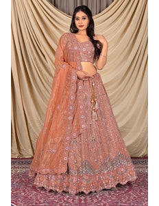 Woman wearing a traditional peach lehenga with floral patterns