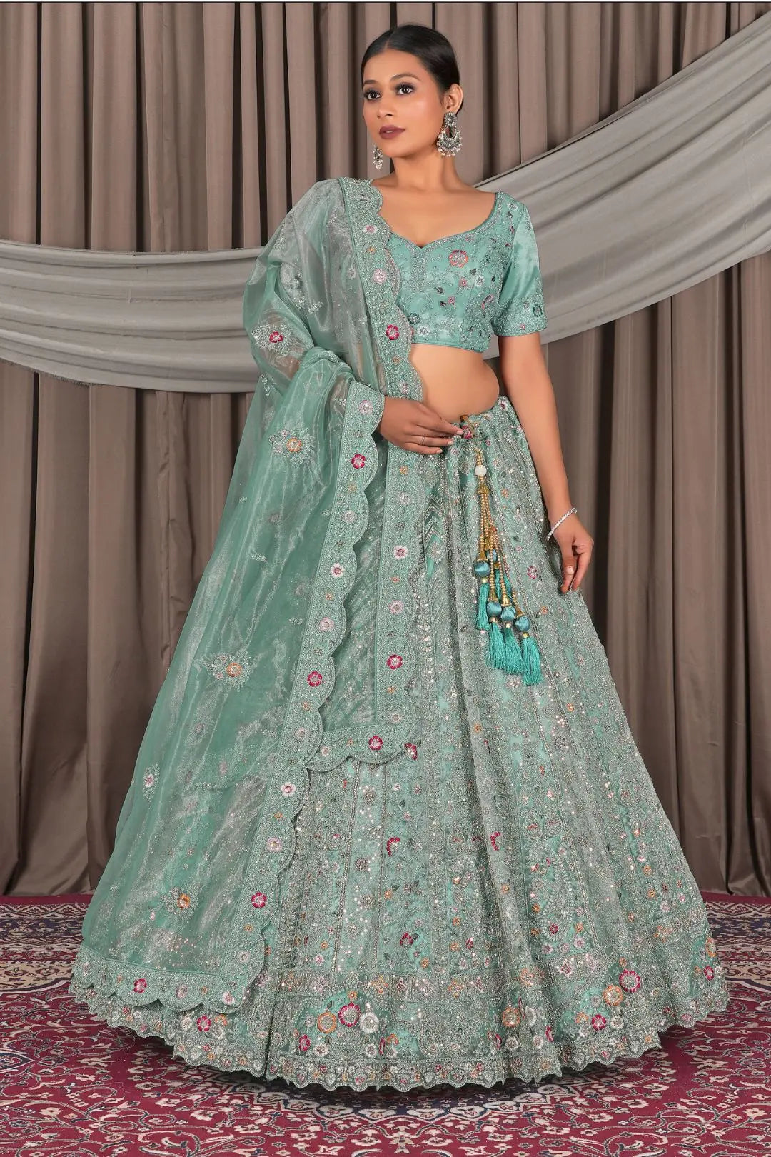 Woman wearing a traditional green outfit with floral patterns