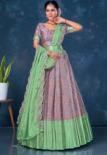 Woman wearing a traditional outfit with a green and pink patterned lehenga choli with dupatta