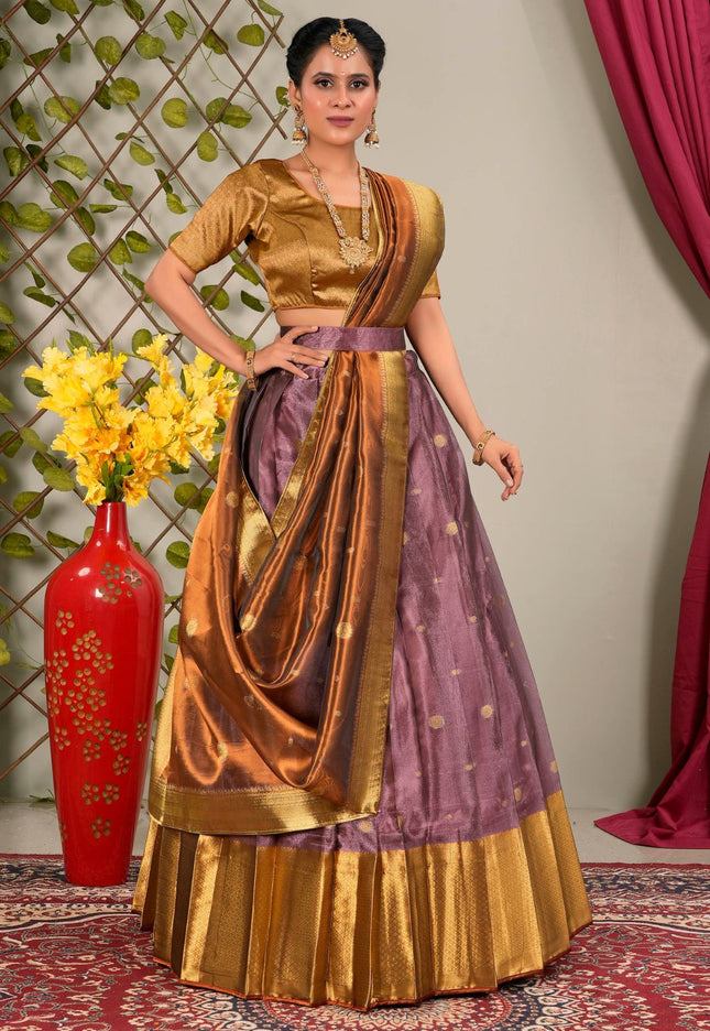 Woman in traditional gold and purple lehenga choli with dupatta