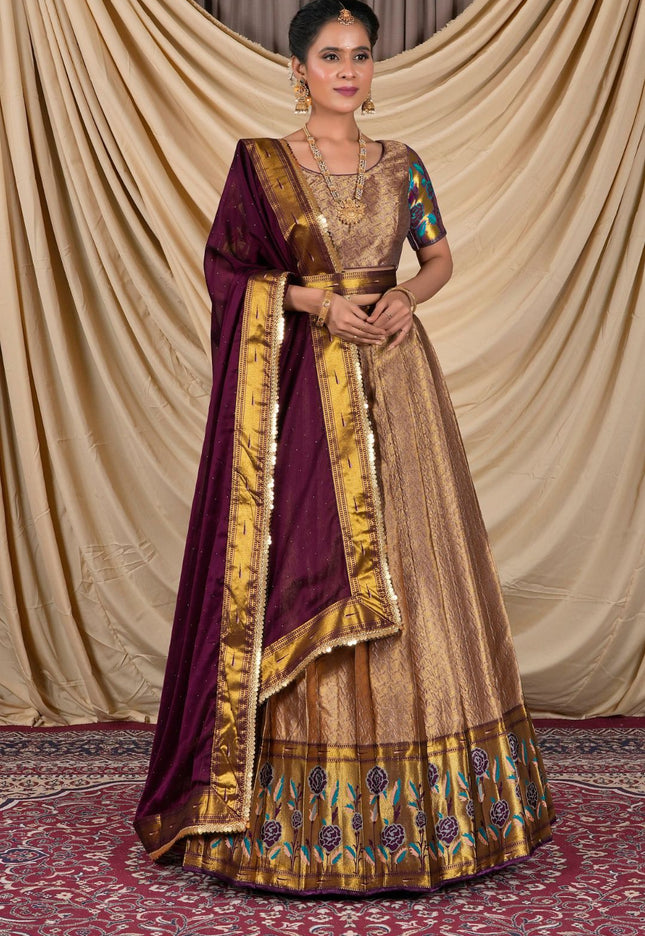 Woman wearing a traditional gold and purple lehenga choli with dupatta
