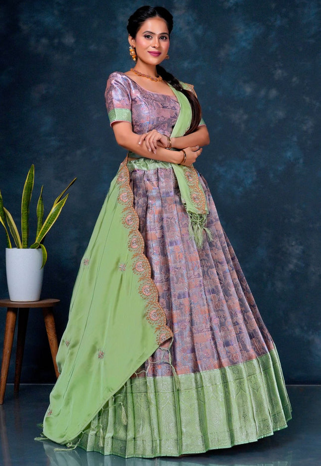 Woman wearing a traditional outfit with a green and purple patterned lehenga choli
