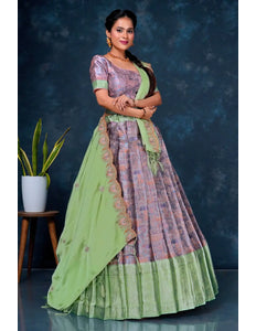 Woman wearing a traditional outfit with a green and purple patterned lehenga choli