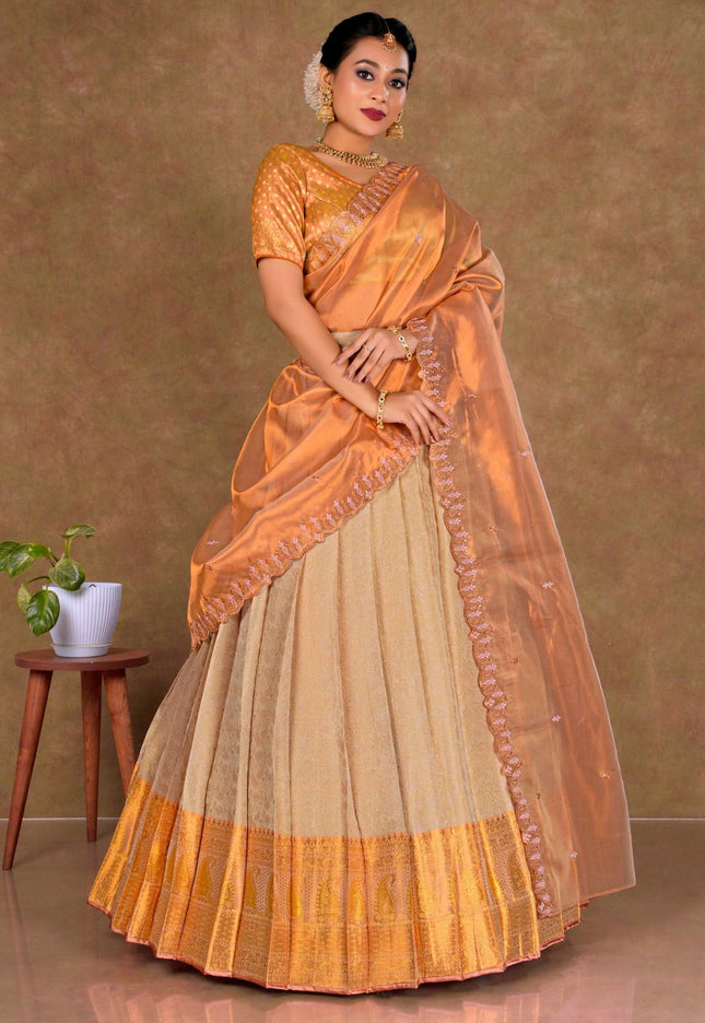 Woman wearing an orange and beige lehenga choli with dupatta
