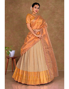 Woman wearing an orange and beige lehenga choli with dupatta