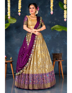 Woman in a traditional gold and purple lehenga choli with dupatta