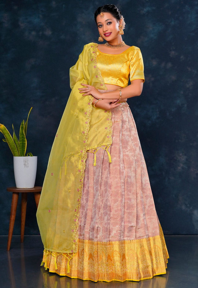 Woman wearing a yellow and pink traditional lehenga choli with dupatta