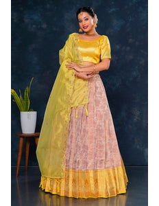 Woman wearing a yellow and pink traditional lehenga choli with dupatta