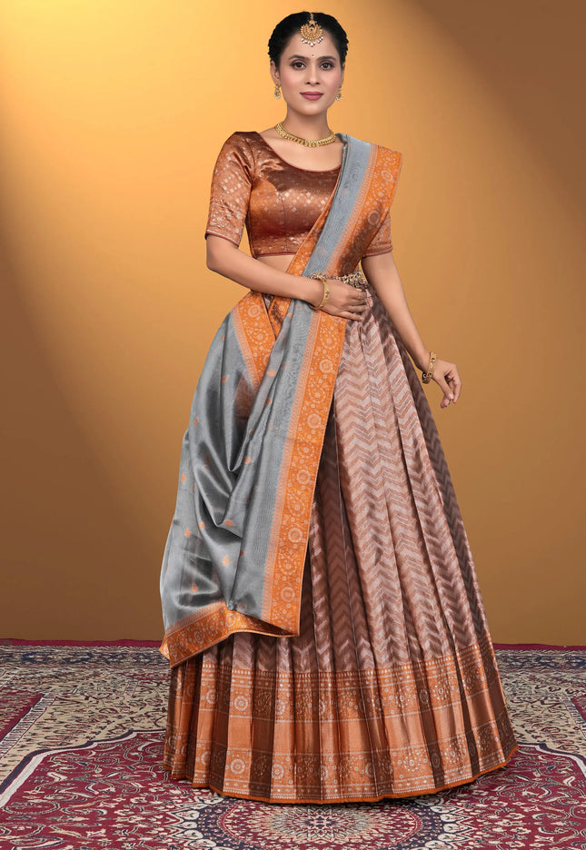 Woman wearing a traditional saree with a brown blouse and peach lehenga