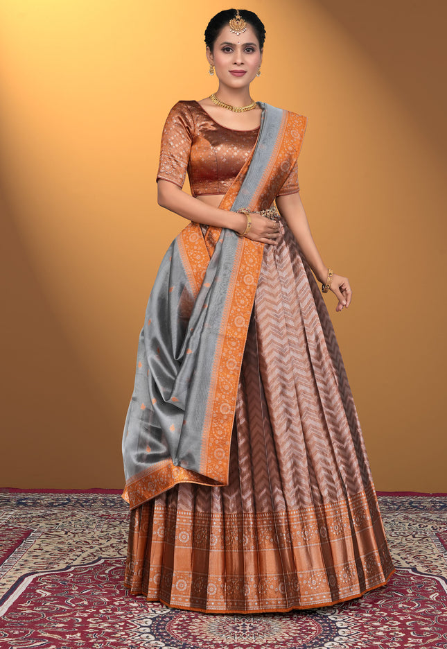 Woman wearing a traditional saree with a brown blouse and peach lehenga