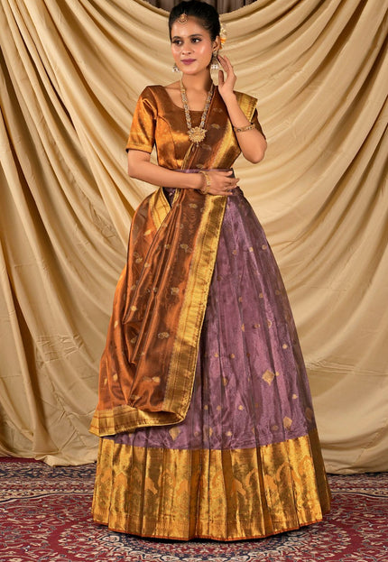 Woman wearing a traditional outfit with a gold and purple lehenga choli with dupatta