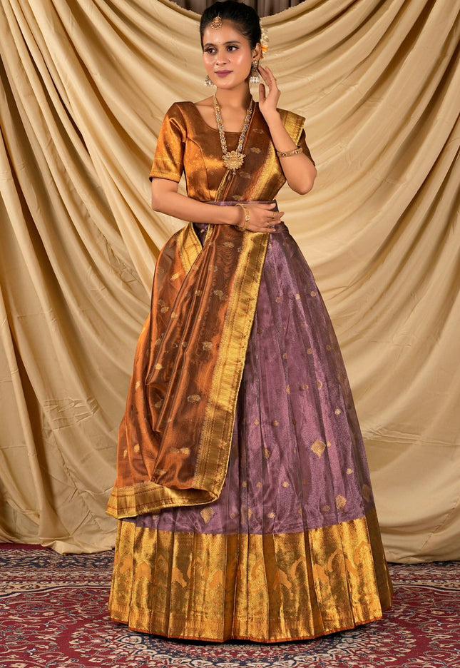 Woman wearing a traditional outfit with a gold and purple lehenga choli with dupatta