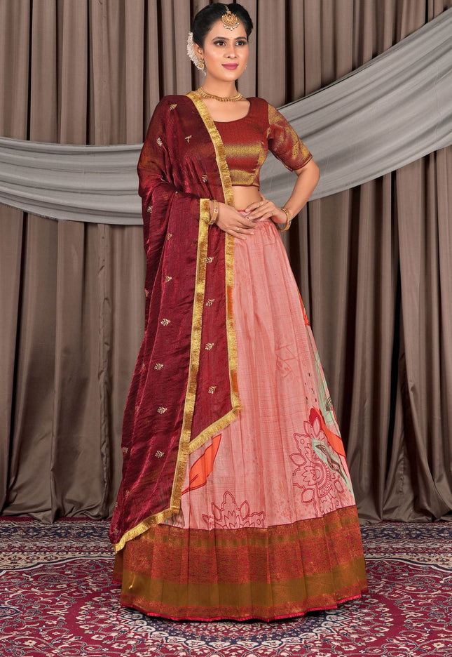 Woman wearing a traditional maroon and pink saree with a gold border