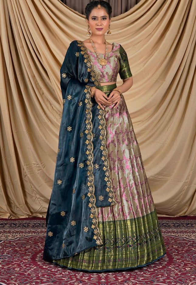 Woman wearing a traditional blue and pink lehenga choli with a gold border.