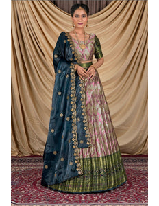Woman wearing a traditional blue and pink lehenga choli with a gold border.