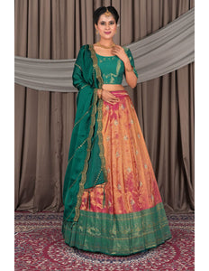 Woman wearing a traditional green and pink lehenga with a matching dupatta