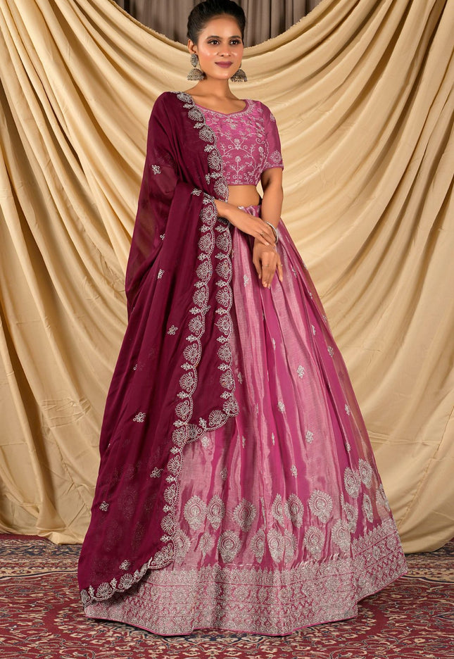 Woman wearing a pink and purple traditional lehenga choli with dupatta