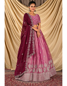 Woman wearing a pink and purple traditional lehenga choli with dupatta